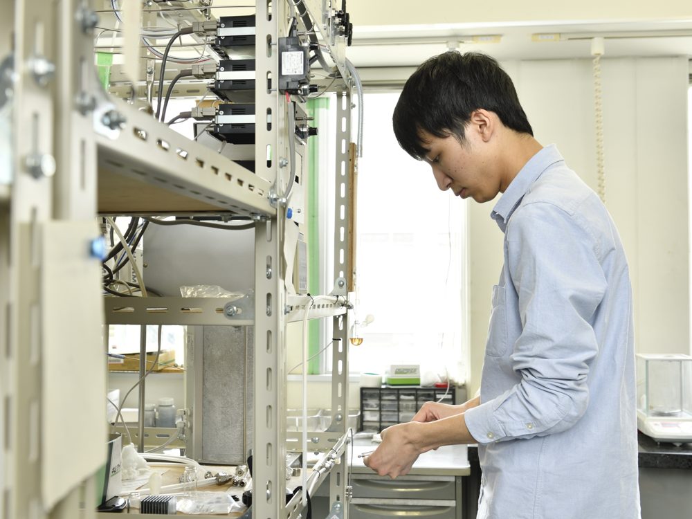 流通式の反応装置で実験する学生